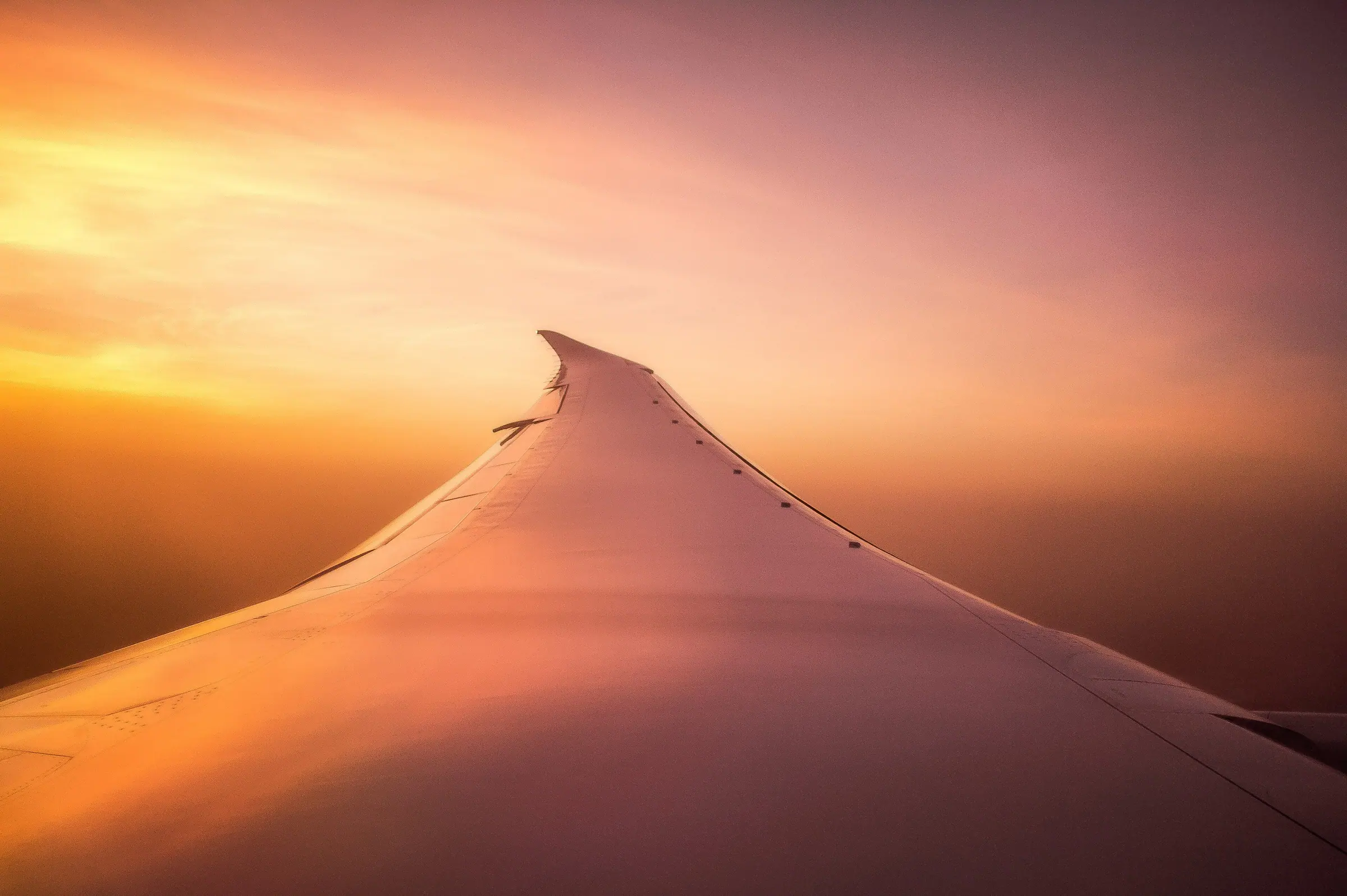 A wing above the clouds at sunset